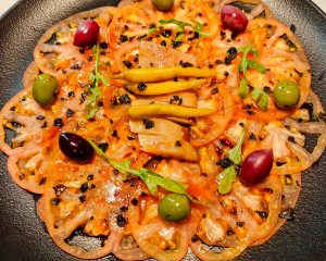 Carpaccio de tomàquet prèmium amb lloms d’Arengada fumada a KRAM Andorra la Vella! 🍅🐟✨   🔥 Un entrant delicat, fresc i ple de contrastos! 🔥   A KRAM Andorra, la gastronomia es viu amb passió i detall, i aquest plat ho demostra:   🍅 Tomàquet prèmium tallat finament per ressaltar la seva dolçor i frescor   🐟 Lloms d'arengada fumada que aporten intensitat i un toc sofisticat   🌿 Amaniment suau i equilibrat per potenciar cada matís del plat   ✨ Una combinació que sedueix el paladar i et convida a gaudir de l’essència mediterrània!   📍 Reserva la teva taula i descobreix infinitat de sabors innovadors a KRAM Andorra la Vella!   #KRAMAndorra #CarpaccioDeTomàquet #SardinaFumada #GastronomiaDeQualitat #MenjarQueCaptiva #EntrantIrresistible #CuinaMediterrània #SaborsAutèntics #MomentsGastronòmics #ReservaJa #CuinaDeProximitat #PassióPelProducte #ExperiènciaÚnica #MenjarAmbEncant #OnMenjarBé #SaborsQueEnamoren #GastronomiaPremium #AndorraTaste  