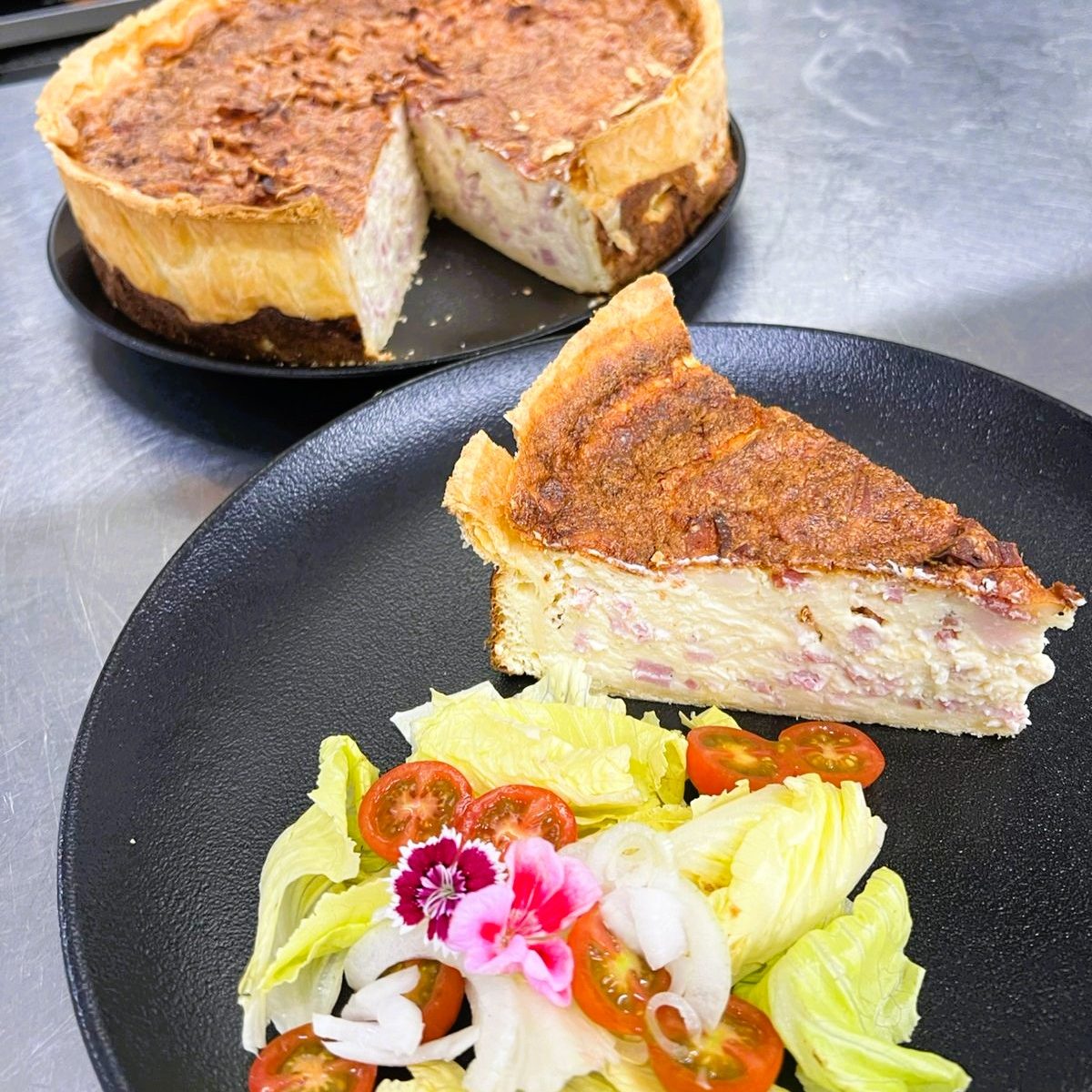 Chez KRAM ANDORRA, redécouvrez la quiche Lorraine authentique : 🔸 Pâte brisée croustillante. Mélange onctueux d’œufs et crème fraîche (la fameuse migaine) Lardons fumés qui apportent la touche salée parfaite...